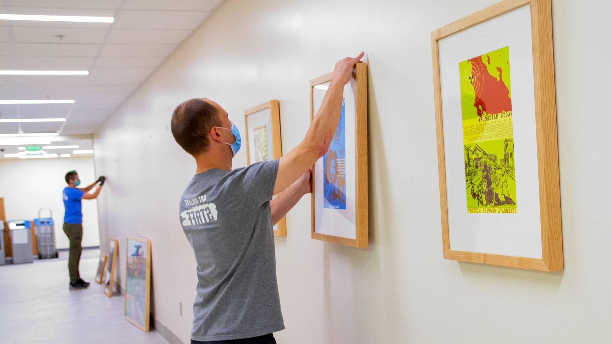art gallery team installing artwork in hallway